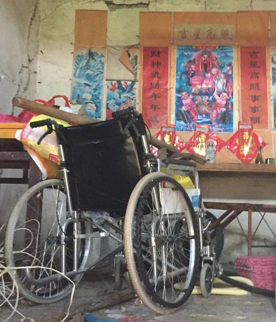 朱老头堂屋内，和其他物件相比，他病重时坐的轮椅显得很新。新京报记者陶若谷 摄