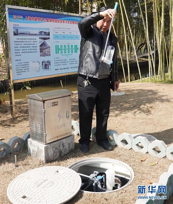 上海市崇明区三星镇的工作人员在展示经过处理的水（2018年2月27日摄）。上海市崇明区三星镇为保护农村水源安全，计划为村民铺设污水排放管网，建立污水处理站，通过一级物理处理、二级生化处理，有效治理区域性水体污染问题。新华社记者 丁汀摄