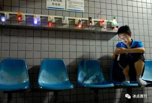 　2012年5月9日，广东省东莞市，打工者在集体宿舍的手机充电处。视觉中国供图