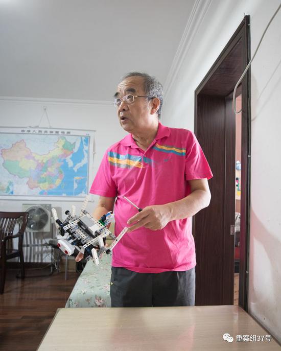 ▲8月6日，沙有威在家中向新京报记者讲解手中的机器人。 新京报记者 彭子洋 实习生 阚子青 摄
