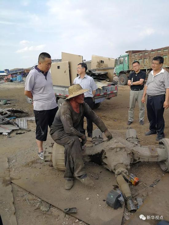 6月19日,督察人员在一家汽车拆解企业向工作人员了解情况。新华社记者高敬摄