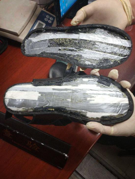 海关人员在拖鞋夹层中发现疑似毒品的粉末状物。