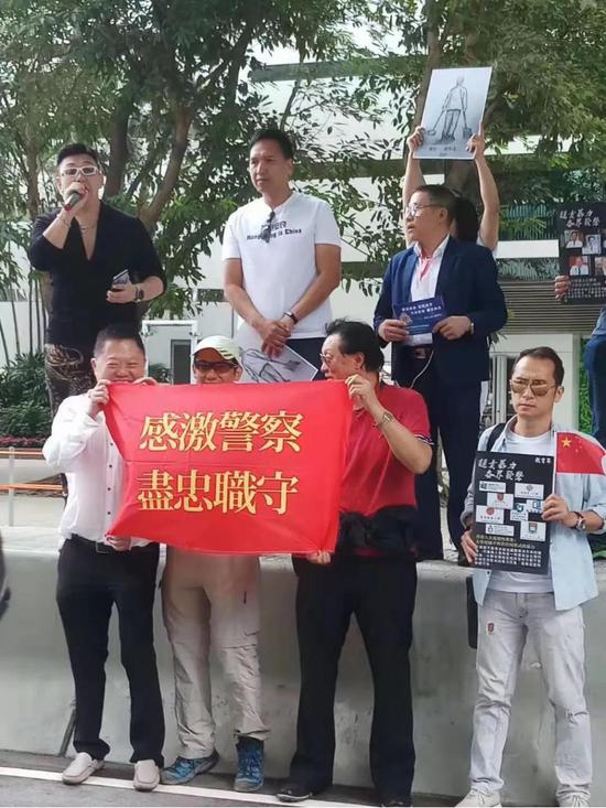 (图:活动现场,市民们拉起横幅)