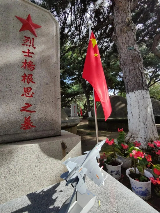烈士杨根思墓碑前的“歼-15”战斗机模型