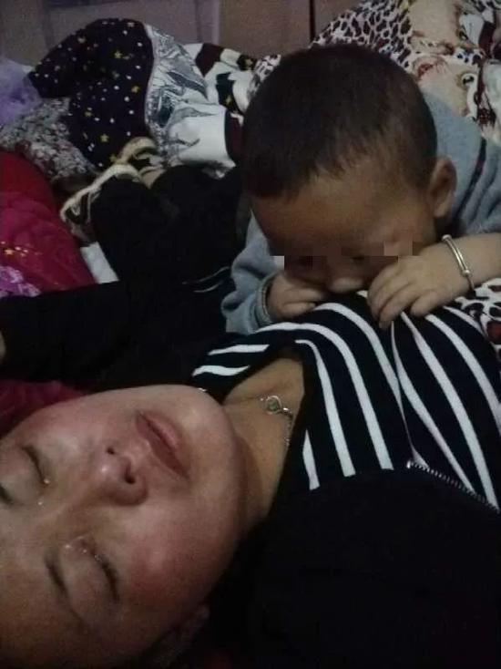 5月25日，杨美芹接受采访时情绪崩溃痛哭不止，图为杨躺在床上哭泣，小儿子俯在妈妈身上。实习生王露晓 摄