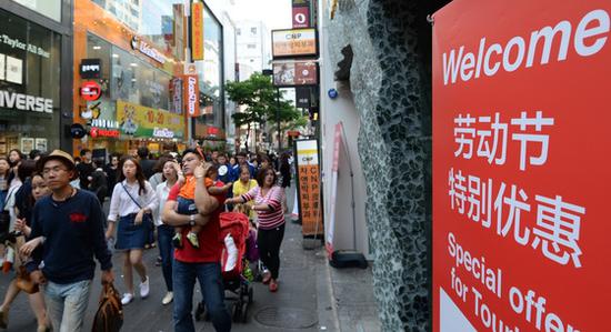资料图:韩国商家打出中文标语,欢迎中国游客。