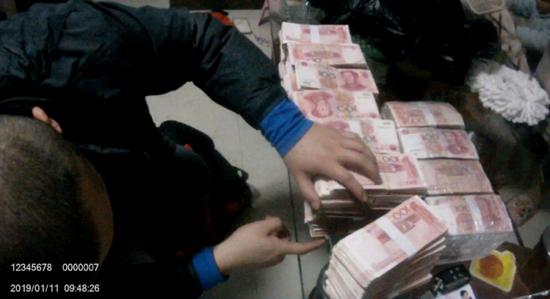 辦案人員查獲涉案現金 視頻截圖來源:公安部