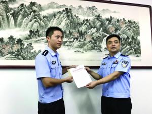 润州公安分局纪委书记王洪来（右）向王伟递交正名通知书和激励金