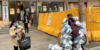 2月24日,在武汉市江岸区黄石路汉口大药房,为病人送药的小区事情者(右1)把为住民购置近100份的药挂全身上预备脱离。(图片泉源:新华社)