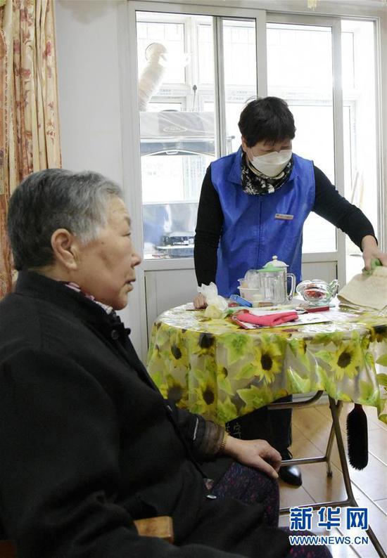 甘肃省兰州市城关区广武门街道助老服务员李小平（右）在马玉英老人家里打扫卫生（3月20日摄）。 新华社记者 王朋 摄