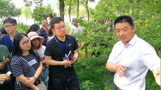 汉丰湖国家湿地公园负责人向媒体记者介绍湿地生态治理情况。
