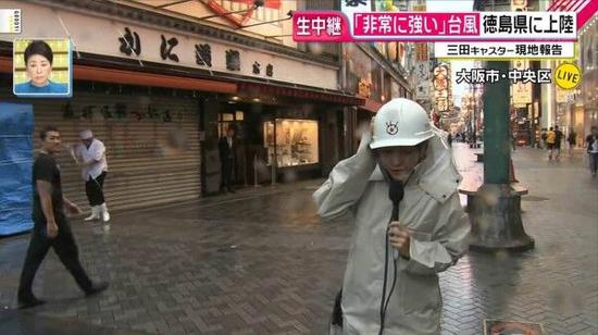 记者播报台风灾情“被吹得”站不稳 路人淡定逛街