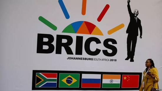 ▲在南非桑顿举行的第10届金砖国家峰会之前，一位代表走过了金砖五国的标志。（路透社）