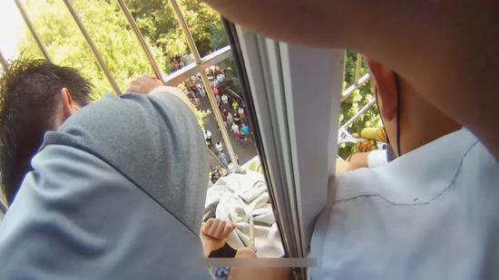 惊险!七岁女童悬挂窗外 民警和消防员拆护栏救孩子