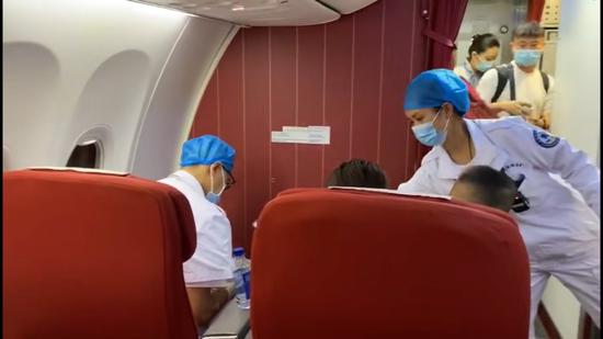  航班抵达广州后救护医生登机为小旅客进行全面检查