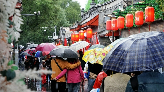 10月6日，游人冒雨游览北京南锣鼓巷。新华社记者 李欣 摄