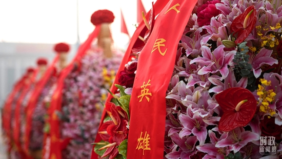 △仪式现场大型花篮的红色缎带上,书写着“人民英雄永垂不朽”的金色大字。(总台央视记者王威拍摄)
