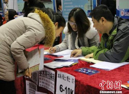 资料图：山东大学2018届毕业生就业双选会（秋季）11月25日在济南举行。图为求职学生向用人单位咨询招聘条件。　赵晓 摄