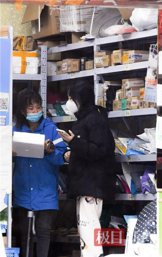 在洪山区卓刀泉街一家快递点内,工作人员把包裹递到收件人手中