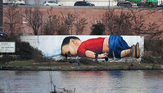 2016年3月10日，德国法兰克福港口现溺亡叙利亚难民男孩Alan Kurdi的巨幅涂鸦。图片来源：视觉中国