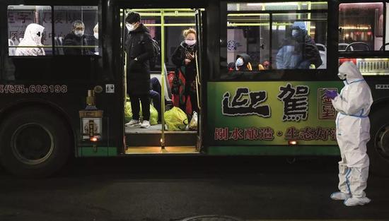 2020年2月5日晚9时,首批新冠病毒肺炎轻症患者连续抵达武汉国际会展中心方舱医院。摄影/陈卓