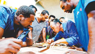 2018年8月28日，来自非洲的学员在四川省泸州市纳溪区白节镇学习竹灯饰灯圈的钻孔、穿条技术。人民视觉