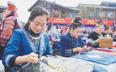 陆婷(左一)带领老乡们一起制作刺绣。 资料图片