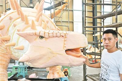 郭其洪与制作的“恐龙”在一起。