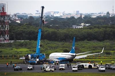 8月17日，菲律宾马尼拉，一架起重机吊起厦门航空公司偏离跑道的受损客机。 图/视觉中国