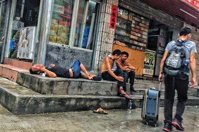 8月12日下午4点，三和人力市场附近的小巷中，喝醉的打工者躺在路边，新来的打工者拖着行李从一旁走过。