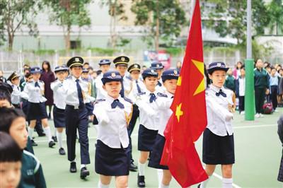 香港爱国学校的小学生在校园升旗礼上（图源：人民日报海外版）