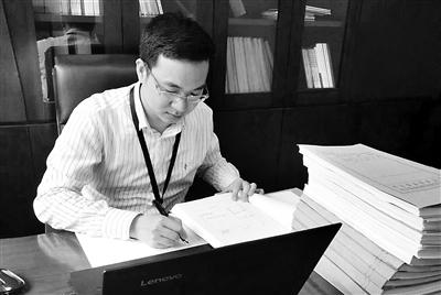 图为罗功新在查阅相关资料。 顾敏 摄