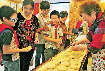高林荣为社区居民现场制作糖饼。 （温沁 摄）