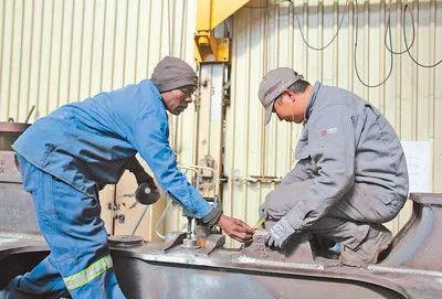  在中国中车南非比勒陀利亚工厂内，中南员工一起工作。 人民日报记者 李志伟摄
