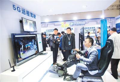 11月14日,在第十五届“中国光谷”国际光电子博览会上,观众在中国移动展区体验5G远程驾驶。新华社记者 熊 琦摄