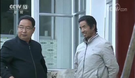 李培东(左)与村民在一起