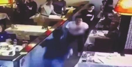 ◀案发现场的监控视频显示:周凯旋(蓝衣人)持刀刺向谢雕(白衣者)。