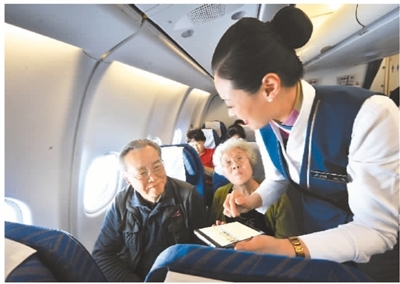 2018年1月18日开始，根据民航总局的规定，航空乘客可以在飞机上使用手机。图为航空人员在帮助乘客使用手机上网。 　　楚洪雨摄（人民图片）