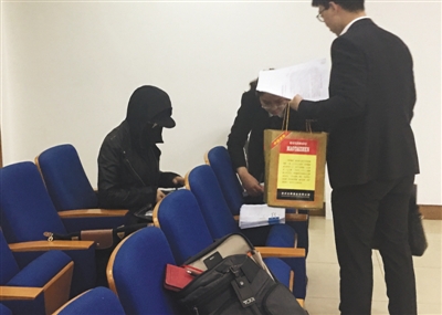 严密包裹着面部的原告王女士（左一）坐在法庭旁听席上参与庭审。新京报记者 左燕燕 摄