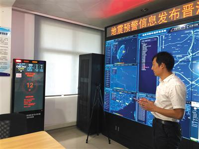 福建省晋江市地震预警信息发布分中心,技术人员模拟演示终端机发出预警信息的情景。新京报记者 周依 摄