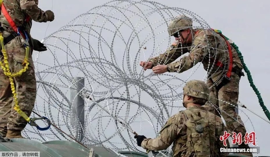 资料图：美军士兵在美墨边境安装防止移民越境的铁丝网。