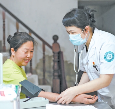在浙江省台州市椒江区洪家社区一名慢性病患者家里，社区卫生服务中心蔡海红医生正在为患者开展上门随访服务。张守华摄