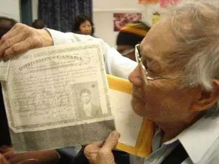 △加拿大华人手持其父1918年缴纳完“人头税”后获得的移民书证。