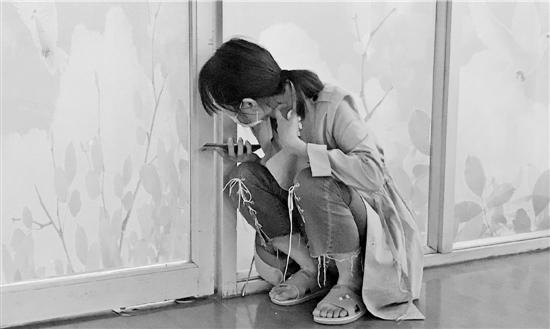 张婷从ICU病房门缝里往里面看,心牵烫伤的儿子。