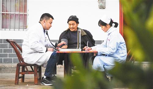 2019年12月26日，重庆市巫山县巫峡镇中心卫生院医护人员在给42岁的绿水村村民丰后植（中）测量血压。　新华社记者　王全超摄