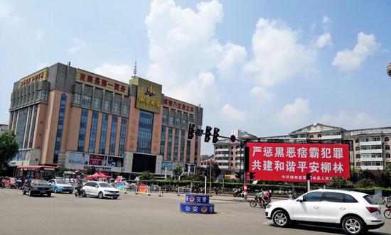 在山西省柳林县,陈鸿志控制的燎原大厦 是当地的高档商厦,其广场前的扫黑除恶的 宣传标语格外醒目。摄影/周群峰