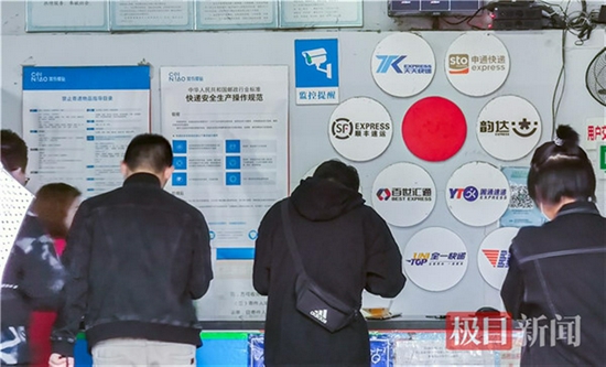 武汉工程大学菜鸟驿站正在给顾客按号取对应快递公司的快件