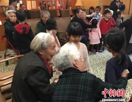 资料图:北京一家养老机构内,老人们与幼儿园小朋友一起做游戏。 杜燕 摄