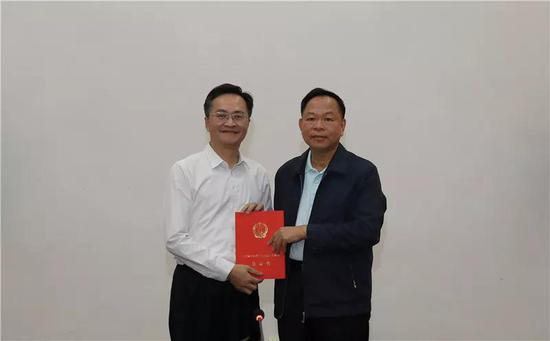 三沙市人大常委会主任徐学健为邓忠(左)揭晓任命书。图源:三沙市政府官网