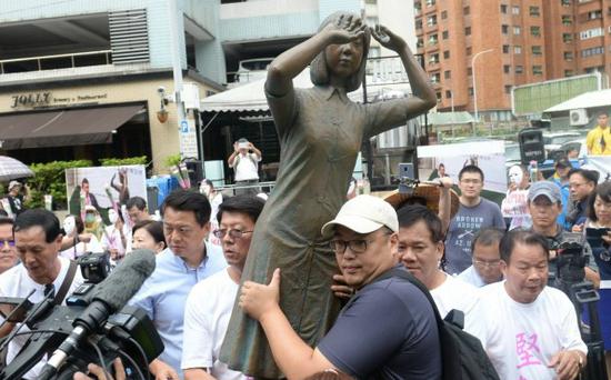 抗议民众携带慰安妇铜像至“台日交流协会”前抗议。(图:台媒)